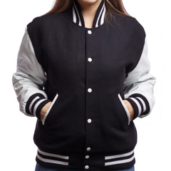 A woman wearing a black and white varsity jacket with leather sleeves and wool body, featuring a button-up front and side pockets.