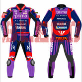 Front and rear views of the Prima Pramac Yamaha MotoGP 2025 racing suit for rider Jack Miller, displaying prominent sponsor logos such as Prima on the chest and back, along with Alpine, Pramac, Yamaha, and the newly added "BLEED" logo on the arms and legs. The suit is primarily blue with red and purple accents. The back of the suit clearly shows the rider name "MILLER"