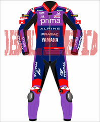 Front view of the Prima Pramac Yamaha MotoGP 2025 racing suit for rider Jack Miller, displaying prominent sponsor logos such as Prima on the chest and back, along with Alpine, Pramac, Yamaha, and the newly added "BLEED" logo on the arms and legs. The suit is primarily blue with red and purple accents. The back of the suit clearly shows the rider name "MILLER"