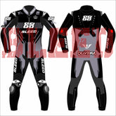 Front and back view of Miguel Oliveira’s 2025 MotoGP test race suit by Bleed, designed in a black, grey, and red theme with “88” branding, RUBY logos on arms and legs, and “Oliveira” on the lower back—featuring aerodynamic paneling and race sponsor logos.