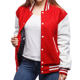 A woman wearing a red and white varsity jacket with leather sleeves and wool body, standing in front of a white background.
