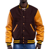 A man wearing a brown and orange varsity jacket with leather sleeves and wool body, buttoned up with metal buttons, and a knitted rib on the collar and cuffs.