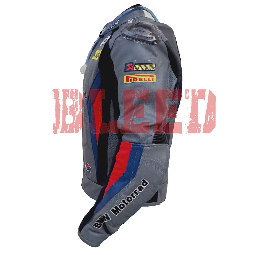 Left side view of the BMW Motorrad Racing Motorcycle Jacket. The gray leather jacket features sponsor logos including Akrapovic and Pirelli on the sleeve, with red and blue accents along the arm. The 'BMW Motorrad' branding is prominently displayed on the forearm, highlighting the jacket's racing-inspired design