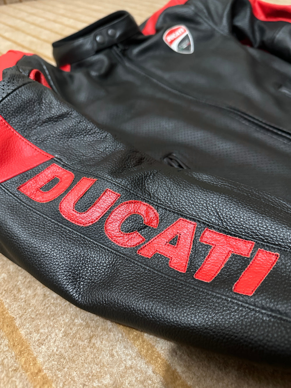 Closeup View of Ducati C4 Leather Motorcycle Jacket – Black and Red Style with Iconic Ducati Logo, High-Quality Perforated Leather, and Sleek Fit for Riders