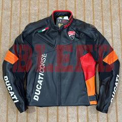 Top-down view of a Ducati Corse C6 motorcycle jacket in black and orange leather, featuring official Ducati branding on the chest and sleeves, with high-quality stitching and a durable design. The jacket includes a red inner collar lining, Italian flag detailing, and the Ducati logo prominently displayed on the chest. The jacket is laid flat on a beige carpet, showcasing its sleek, race-inspired design.