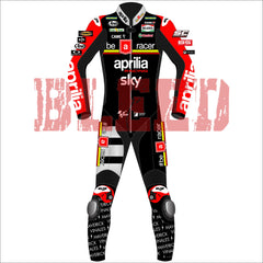 Front view of the 2024 Maverick Viñales Aprilia Racing suit design for British GP featuring a black, red, and white color scheme with prominent sponsor logos like Aprilia, Sky, Michelin. The suit showcases detailed graphics on the legs and arms, personalized for Maverick Viñales.