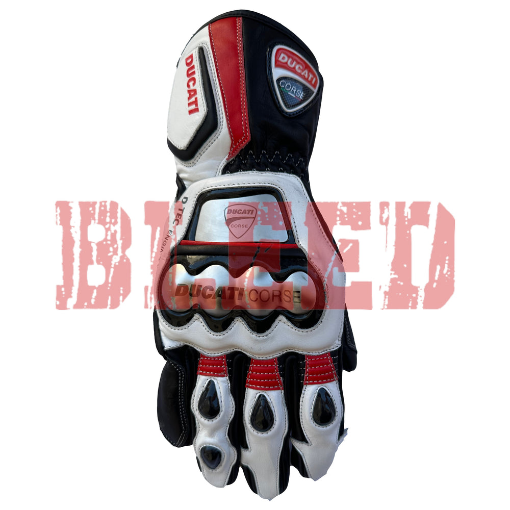 A single Ducati Corse racing motorbike glove is shown, focusing on the front side. The glove features a bold black, white, and red color scheme, with the Ducati Corse logo prominently displayed on the wrist area.