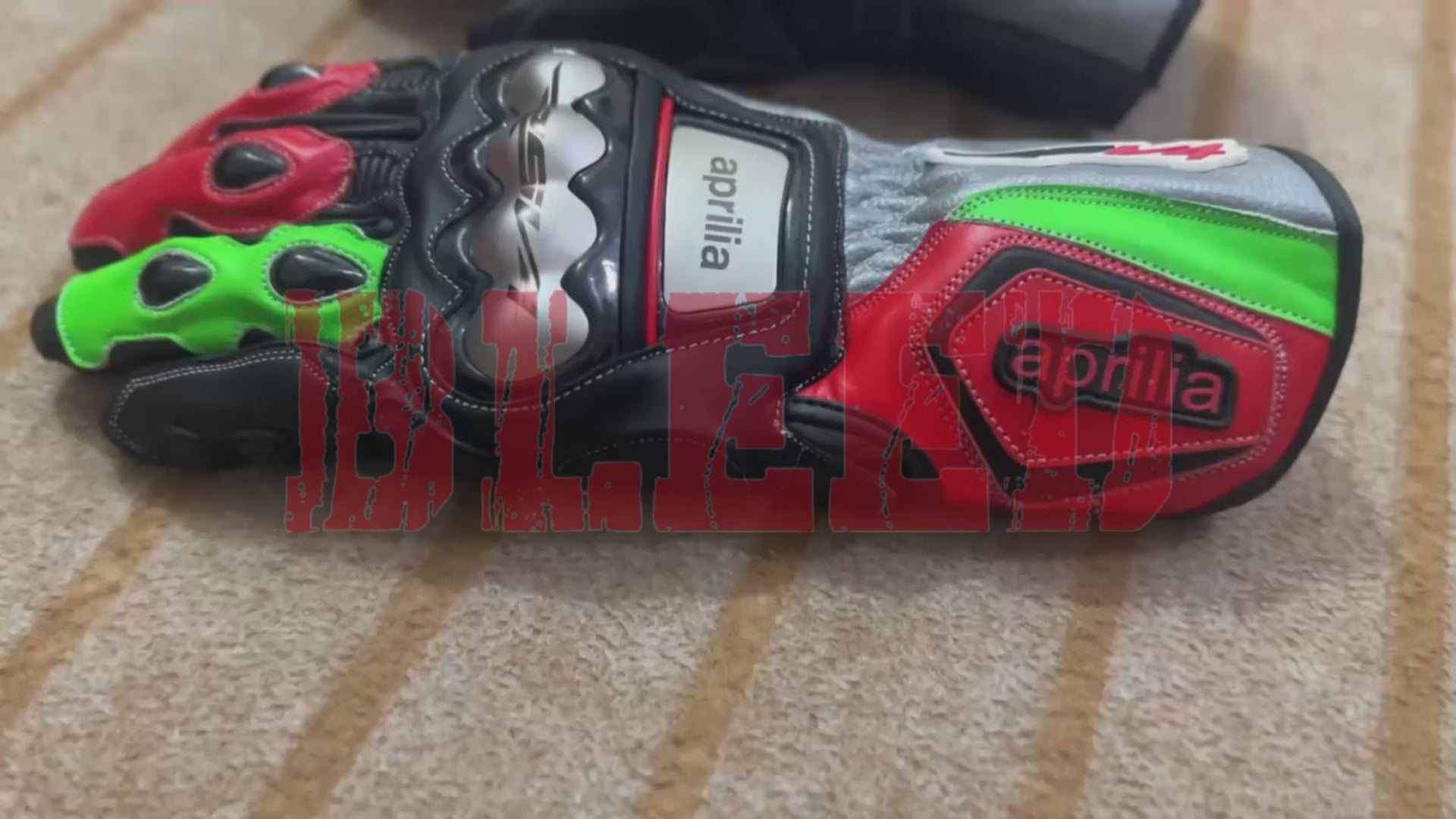 Front view of Aprilia racing motorbike gloves featuring reinforced knuckle protection and vibrant red and green accents by BLEED