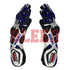 A pair of Suzuki GSXR motorcycle racing gloves shown from the side view. The gloves are predominantly blue, white, and black with red accents. They feature protective knuckle guards, reinforced palms, and finger protection. The Suzuki logo is visible on the wrist area. The gloves are high-performance gear designed for motorcycle racing.